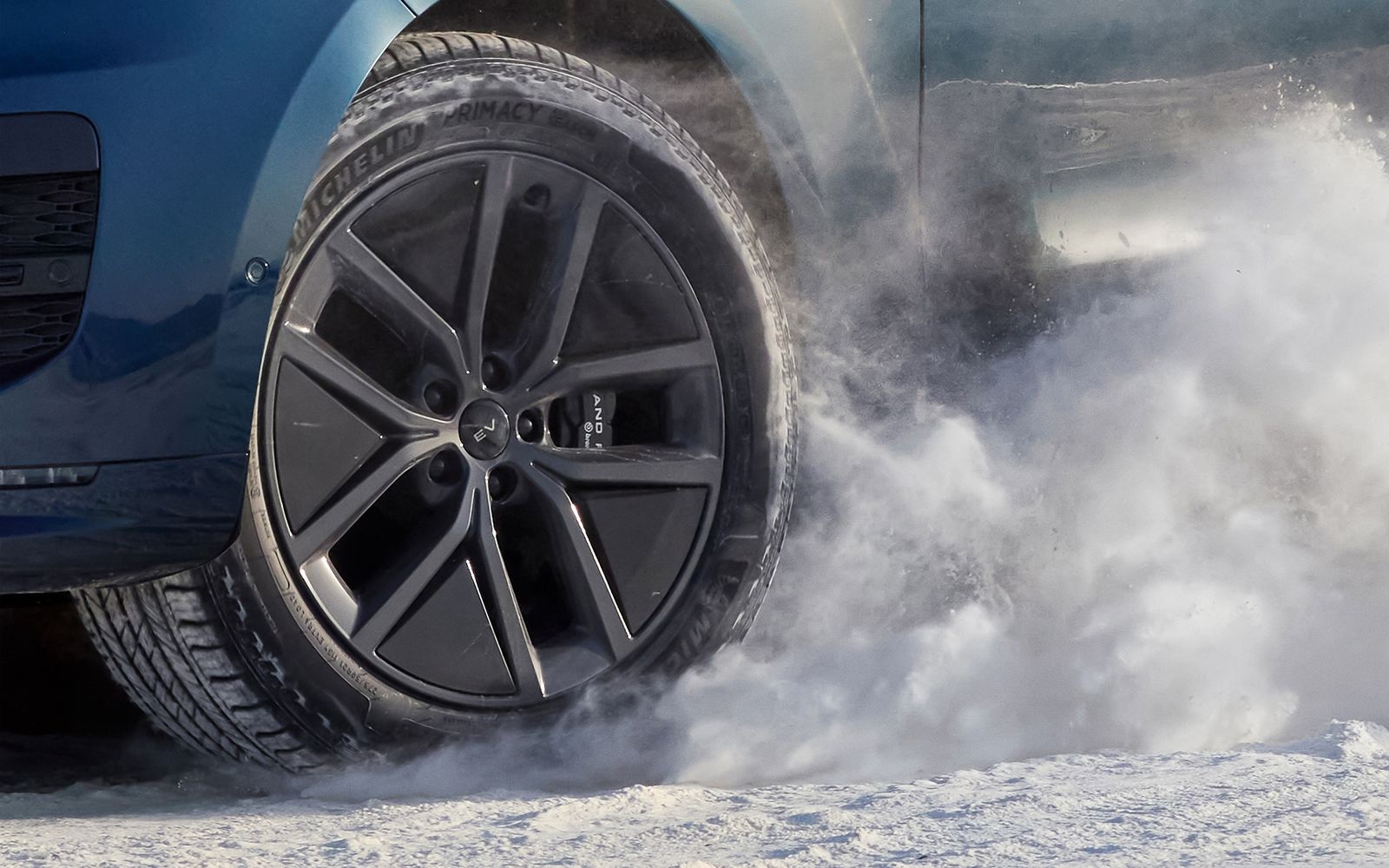 Close detail of a Range Rover wheel in a cloud of powder